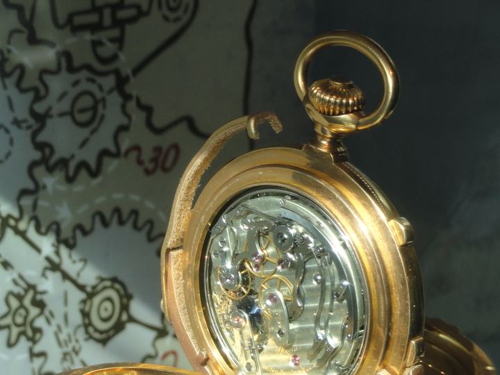 A gold Patek Philippe complicated pocket watch from about 1895 shown open in a museum case