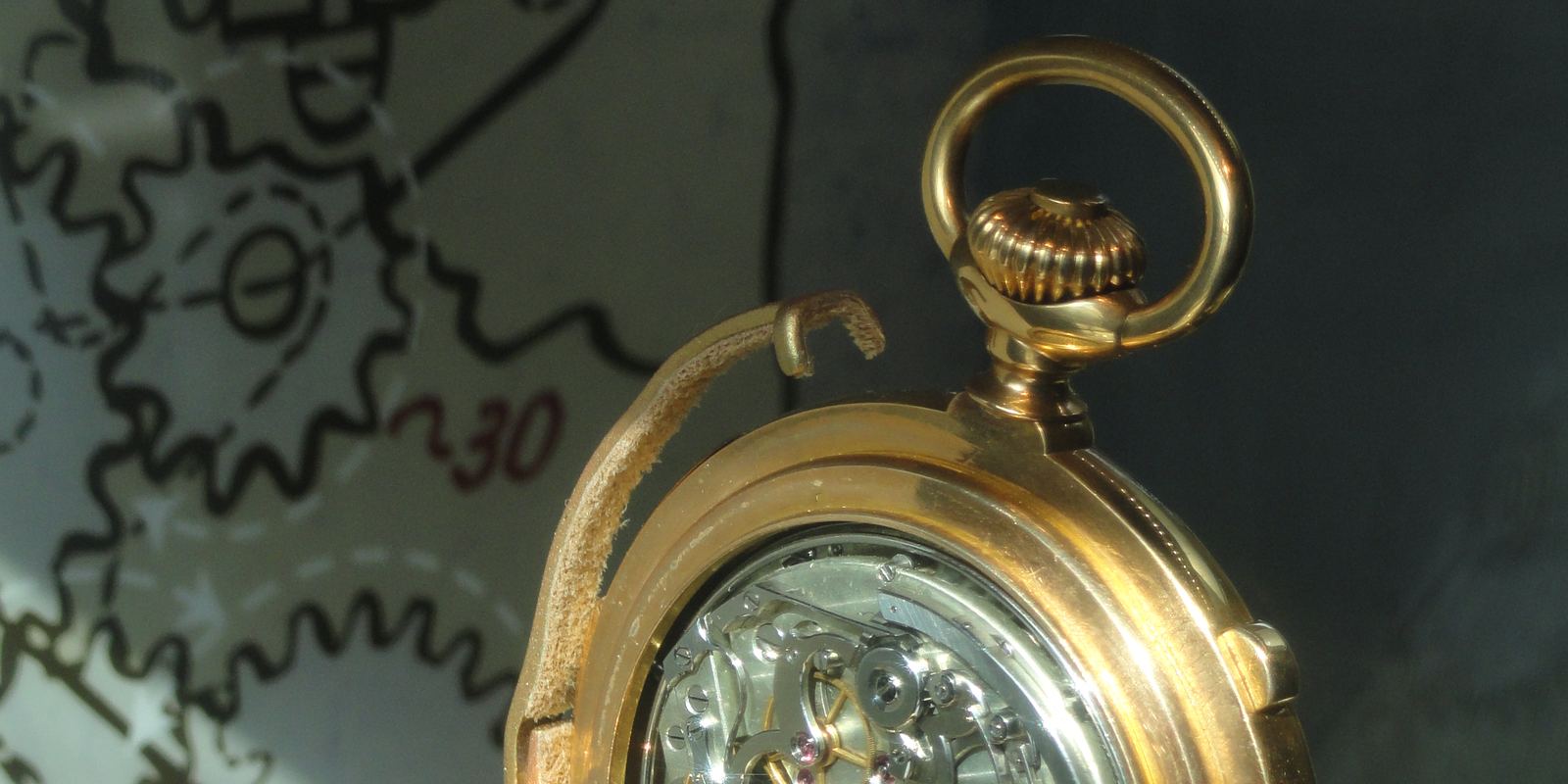 A gold Patek Philippe complicated pocket watch from about 1895 shown open in a museum case