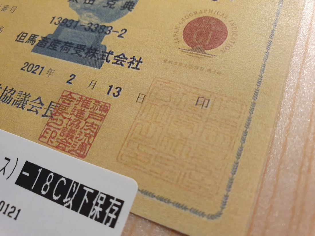 A Kobe beef certificate with stamps and Japanese writing on a box