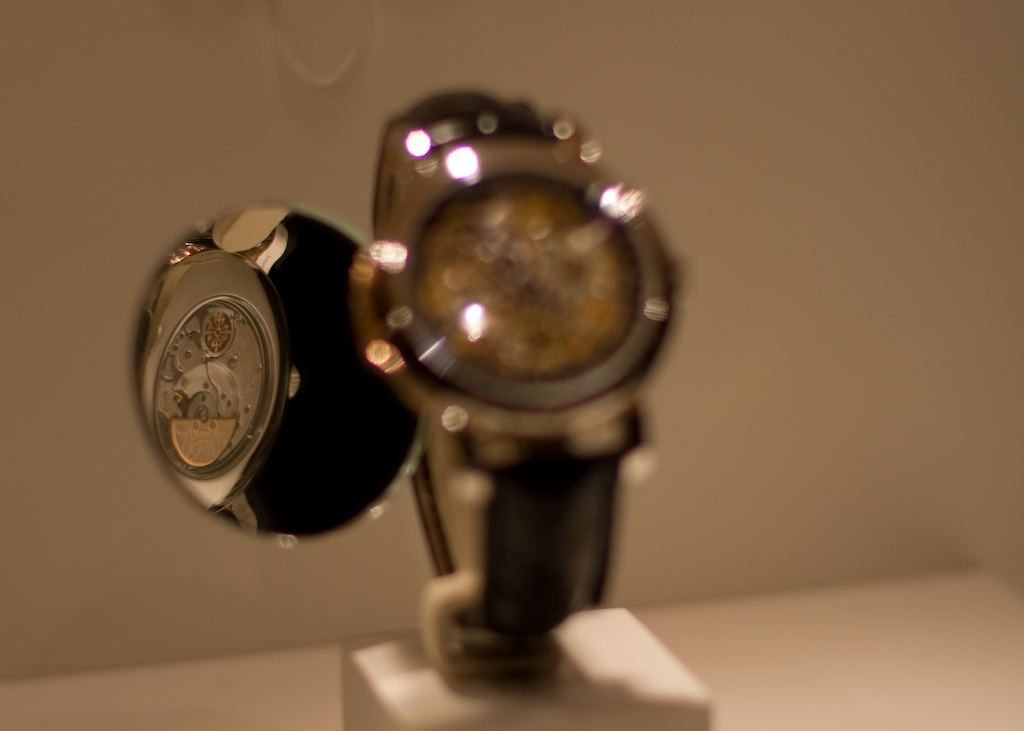 Complicated Patek Philippe watches displayed on stands in a dim exhibition room